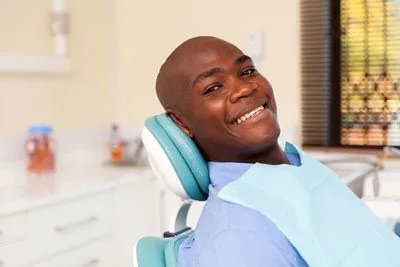man smiling while receiving dental care at Dr. Sumeet Kaur Family Dentistry