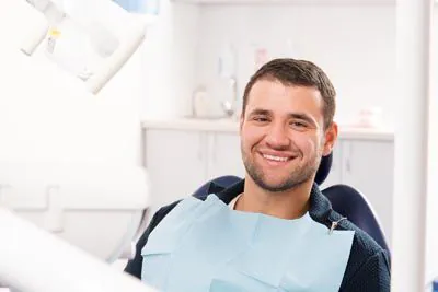 man smiling while receiving dental care
